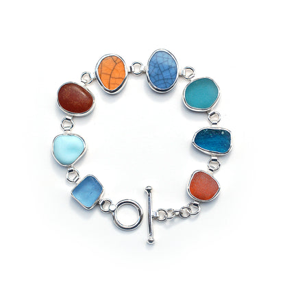 Silver bezel set bracelet with sea glass and pottery pieces on a white background.