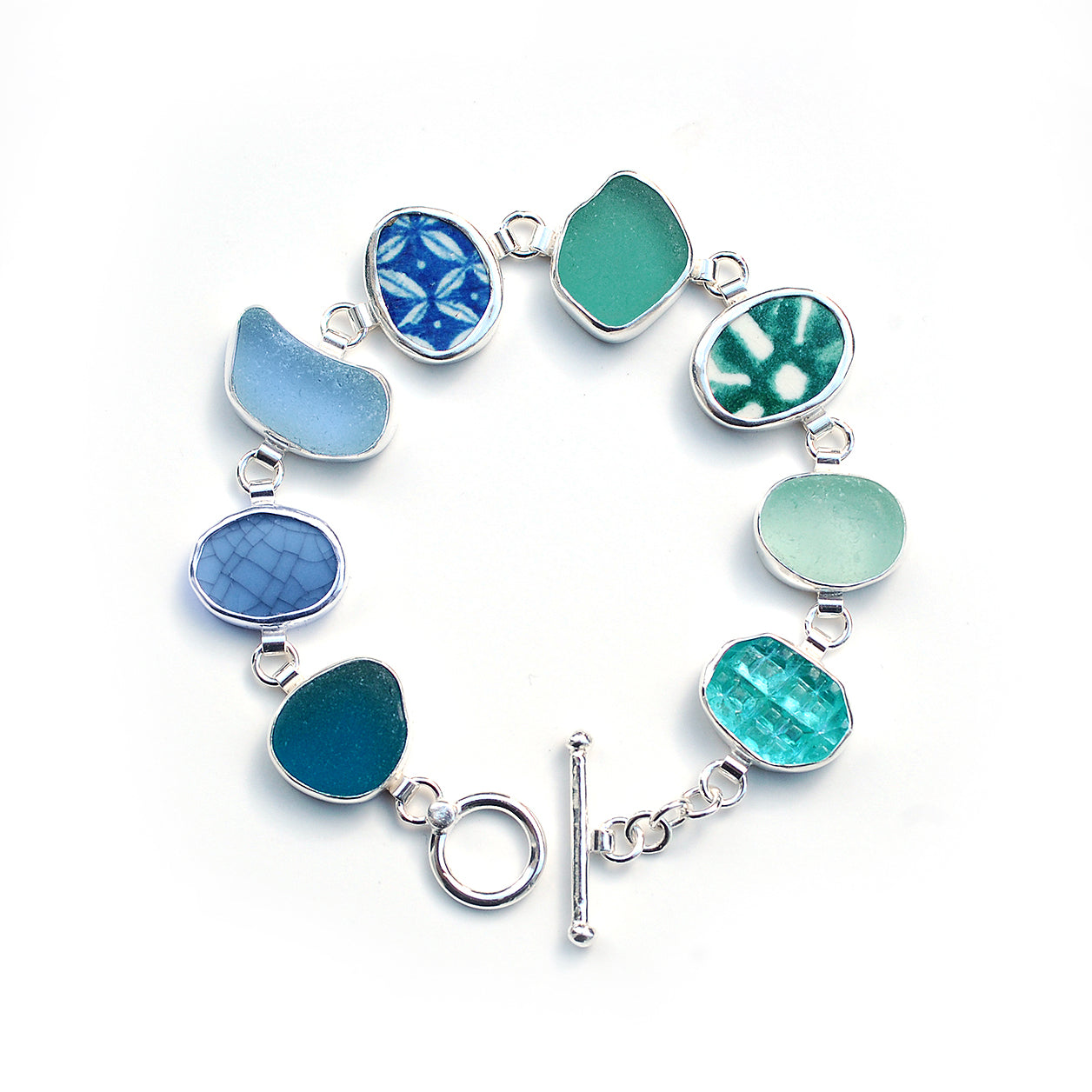 Blue and green sea glass and pottery shard bracelet on a white background.