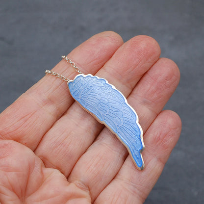 Blue Enamelled Angel Wing Pendant on a hand to show size.