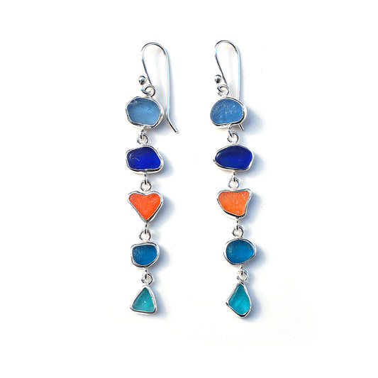 Five drop sea glass earrings in blues and orange, on a white background.