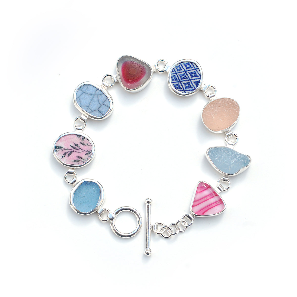 Pink and blue sea glass and pottery shard bracelet on a white background.