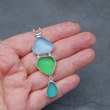 Triple sea glass pendant on a hand