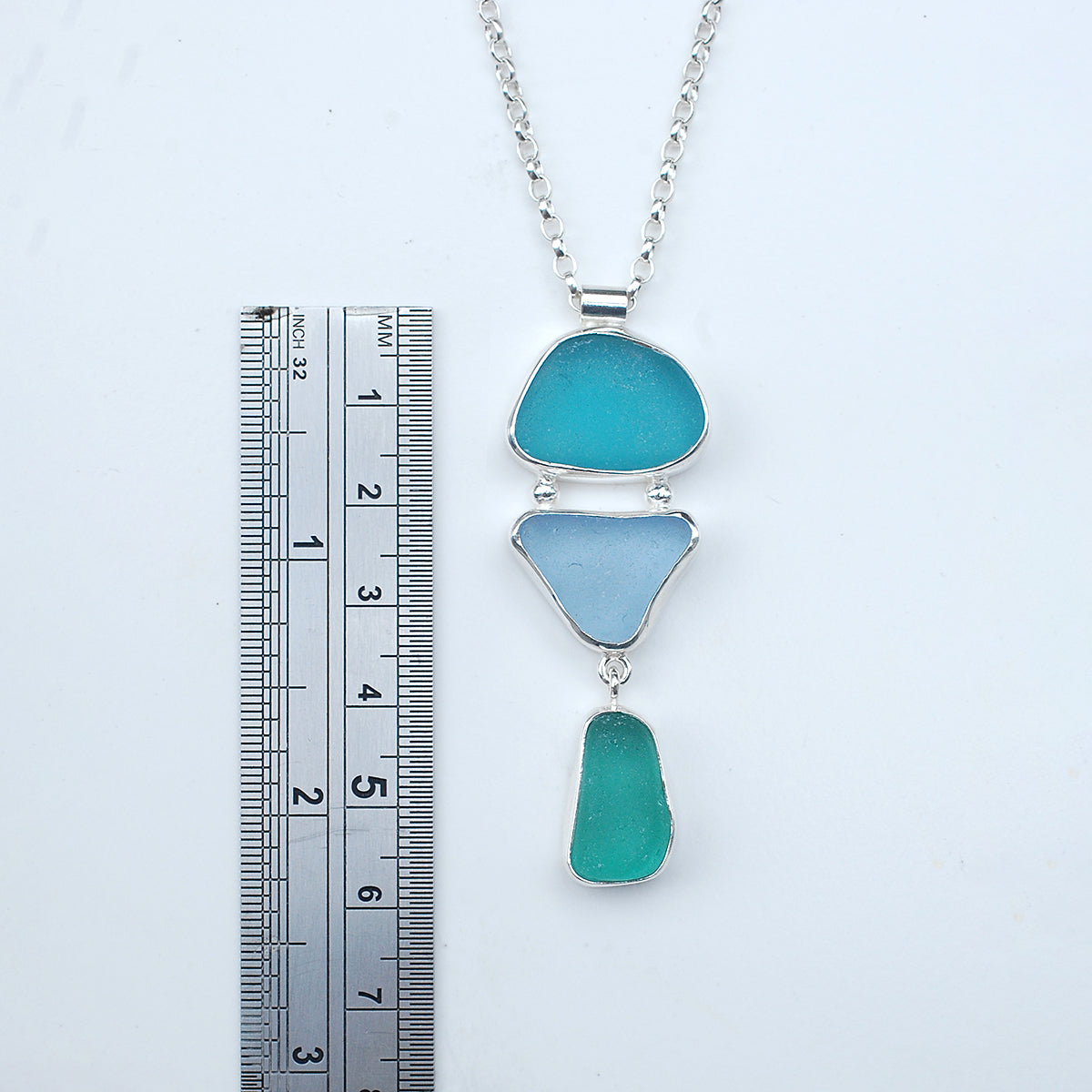 Triple sea glass pendant on a white background, with ruler